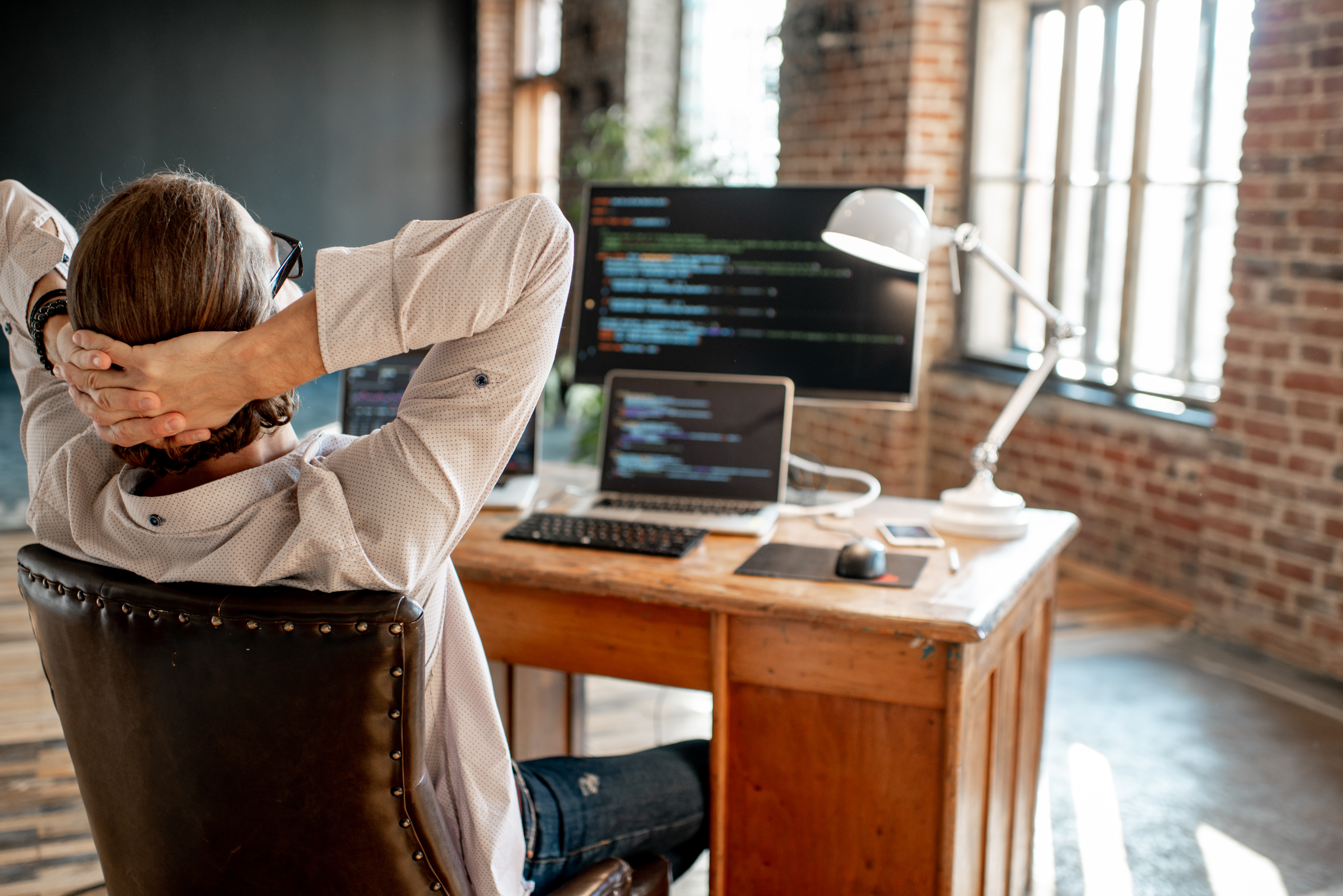 A developer sitting back in his chair, relaxing