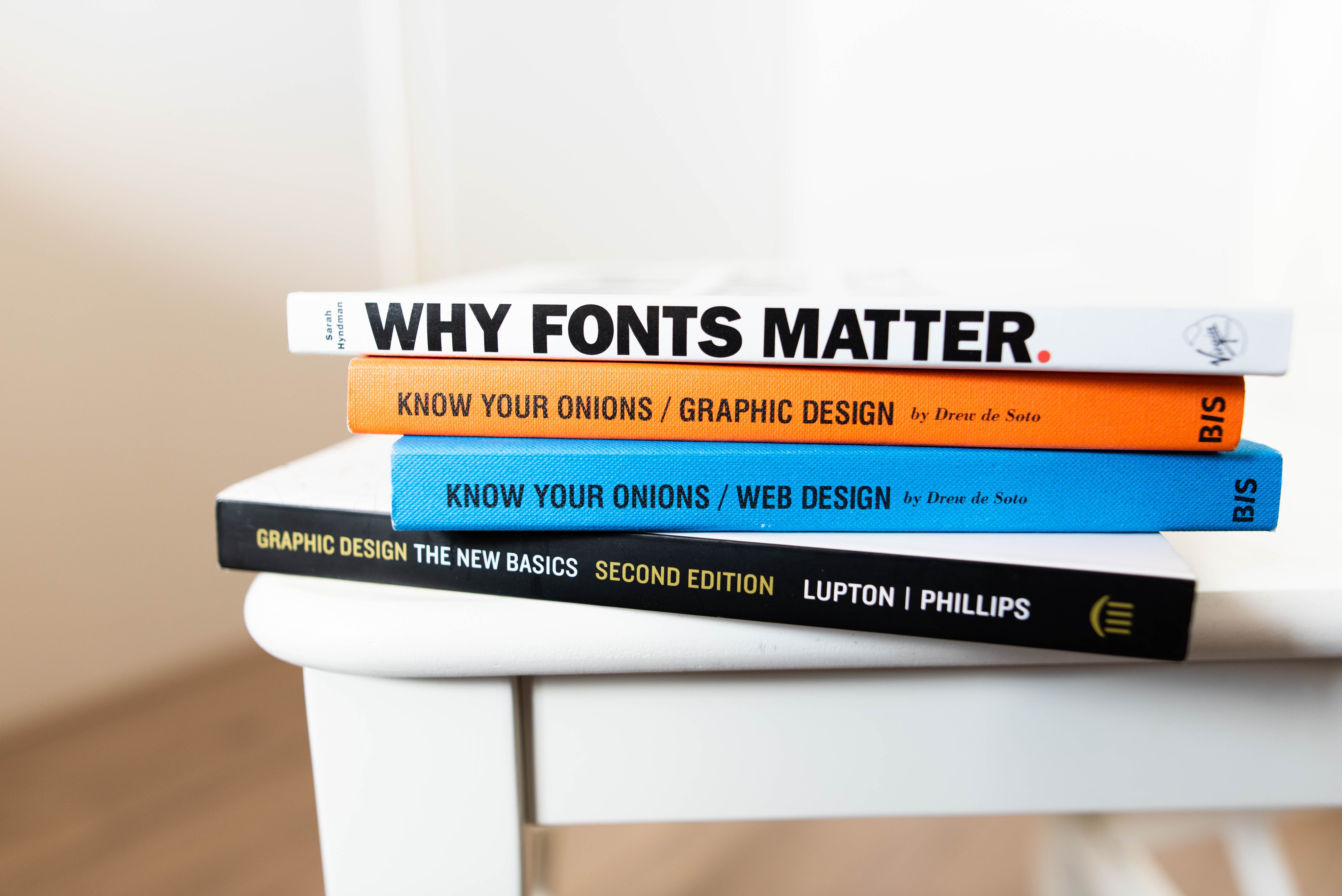 A stack of design-related books on a coffee table